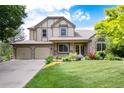 Attractive home exterior featuring a well-kept lawn, stone accents, and attached two car garage at 2480 W Jamison Way, Littleton, CO 80120