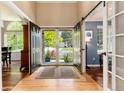 Elegant foyer featuring hardwood floors, barn door, and a view of the landscaped front yard at 2480 W Jamison Way, Littleton, CO 80120