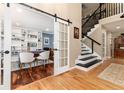 Hallway featuring hardwood floors, white trim, nearby office with barn door, and stairs at 2480 W Jamison Way, Littleton, CO 80120