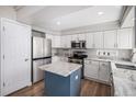 Beautiful kitchen with stainless steel appliances, white cabinets, and a contrasting blue island at 9195 Anasazi Indian Trl, Highlands Ranch, CO 80129