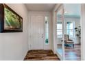 Bright foyer with hardwood floors, a white door, and a view into the living area at 17046 Desert Wine Trl, Parker, CO 80134