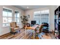 Bright home office with large windows, desk, chair, and stylish decor with hardwood floors at 17046 Desert Wine Trl, Parker, CO 80134