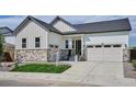 Inviting home exterior boasts stone accents, tidy lawn, and two-car garage at 9197 Ironwood St, Highlands Ranch, CO 80129