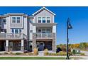 Two-story townhome with gray siding, stone accents, and a balcony at 5245 W 97Th Ave, Broomfield, CO 80020