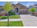 Charming two-story home featuring a stone facade, two-car garage, and well-maintained landscaping at 8844 S Sicily Ct, Aurora, CO 80016