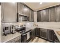 Modern kitchen features stainless steel appliances, granite countertops, and sleek cabinetry at 8833 Meade St, Westminster, CO 80031