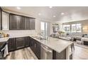 Open kitchen with a large island, stainless steel appliances, and seamless flow into the living area at 8833 Meade St, Westminster, CO 80031