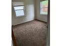 Cozy bedroom featuring two windows for natural light and neutral colored carpet at 165 Garland St, Lakewood, CO 80226