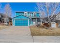 Daytime view of charming two-story home with blue siding, attached garage, and well-maintained front yard at 8731 Wildrye Cir, Parker, CO 80134