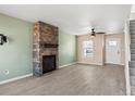 Inviting living room with a stone fireplace, light wood floors, and large windows at 8731 Wildrye Cir, Parker, CO 80134