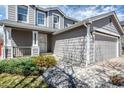 Lovely front yard with new landscaping, a walkway leading up to the gray home with white accents, and a porch at 5237 S Malaya Way, Centennial, CO 80015