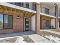 Front entrance of townhome with brick exterior and modern door at 9639 Browns Peak Cir, Littleton, CO 80125