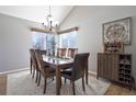 Elegant dining room featuring a chandelier, wooden table with six chairs, and a decorative cabinet at 8915 Edgewood Ln, Highlands Ranch, CO 80130