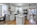 Bright kitchen featuring white cabinets, stainless steel appliances, granite countertops, and hardwood floors at 8915 Edgewood Ln, Highlands Ranch, CO 80130