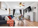 Cozy living room featuring a stone fireplace, a comfortable sofa, and natural light from windows at 3319 E 27Th Ave, Denver, CO 80205