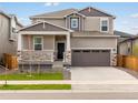 Charming two-story home with a covered porch, stone accents, and a two-car garage at 571 Homestead Ave, Brighton, CO 80601