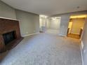 Cozy living room featuring a brick fireplace, carpet, and an open floor plan at 14499 E 1St Dr # A05, Aurora, CO 80011