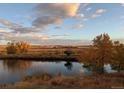 Expansive landscape view with golden trees reflecting into the pond under the beautiful sky at 12431 Red Fox Way, Broomfield, CO 80021