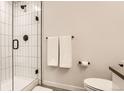 Modern bathroom with tiled shower, glass door, and neutral color palette at 2120 N Downing St # 216, Denver, CO 80205