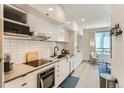Modern kitchen features white cabinets, subway tile backsplash, stainless steel appliances, and recessed lighting at 2120 N Downing St # 216, Denver, CO 80205