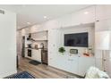A modern kitchen with sleek white cabinets, stainless steel appliances, and an integrated media center at 2120 N Downing St # 216, Denver, CO 80205