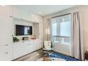 Bright living room with built-in cabinets, large window, and a comfortable chair with a fur throw at 2120 N Downing St # 216, Denver, CO 80205