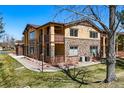 Two-story condo with stone and siding exterior, with well-maintained landscaping at 9816 W Freiburg Dr # A, Littleton, CO 80127