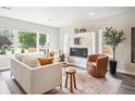 Bright living room with a modern fireplace, neutral decor, and a large window providing ample natural light at 2226 S Galapago St, Denver, CO 80223