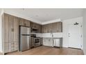 Modern kitchen featuring stainless steel appliances, wood cabinets, and a stylish subway tile backsplash at 3575 Chestnut Pl # 702, Denver, CO 80216