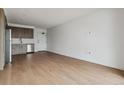 Bright and airy living room featuring wood floors and a modern kitchen with stainless steel appliances at 3575 Chestnut Pl # 702, Denver, CO 80216
