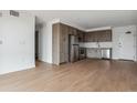 Spacious living room with wood flooring that flows into the kitchen, showcasing open-concept design at 3575 Chestnut Pl # 702, Denver, CO 80216