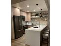 Stylish kitchen with stainless steel appliances, breakfast bar with stools, and floating shelves with décor at 1975 N Grant # 310, Denver, CO 80203