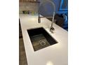 Modern kitchen sink with a sleek faucet, stainless steel basket and bright white countertop at 1975 N Grant # 310, Denver, CO 80203