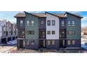 New construction townhome with modern design elements, including a combination of green, white, and gray siding at 8408 W 52Nd Ave, Arvada, CO 80002