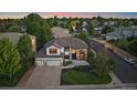 Aerial view of a suburban home with a three-car garage and lush green surroundings at 10701 Flagler Dr, Parker, CO 80134