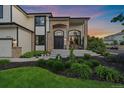 Close-up of a home's entrance with brick accents, a seating area, and manicured landscaping at 10701 Flagler Dr, Parker, CO 80134