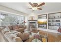 Cozy living room with a stone fireplace, plush seating, and natural light from large windows at 28700 E 160Th Pl, Brighton, CO 80603
