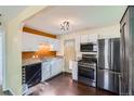 Modern kitchen featuring white cabinets, stainless steel appliances, and dark hardwood floors at 2080 S King St, Denver, CO 80219