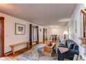 Inviting living room featuring hardwood floors, a sofa, a dining table, and large windows with stylish curtains at 1149 S Kittredge St, Aurora, CO 80017