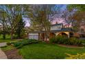 Charming home exterior with well-maintained lawn and mature trees creating a park-like setting at 9765 W 77Th Dr, Arvada, CO 80005