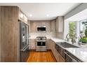 Modern kitchen with stainless steel appliances, light wood cabinets, and hardwood floors at 9765 W 77Th Dr, Arvada, CO 80005