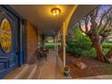 Inviting front porch with seating area, brick accents, and charming curb appeal at 9765 W 77Th Dr, Arvada, CO 80005