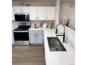 Bright kitchen featuring stainless steel appliances, white cabinets, and quartz countertops with stylish hardware at 10676 Forester Pl, Longmont, CO 80504