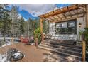 Backyard deck features outdoor seating and a wooden pergola, ideal for entertaining or relaxing outdoors at 846 Circle K Ranch Rd, Evergreen, CO 80439
