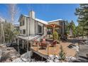 Charming house featuring a spacious wooden deck with an outdoor seating area and a pergola at 846 Circle K Ranch Rd, Evergreen, CO 80439