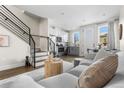 Open concept living space featuring a comfortable sofa, staircase, and kitchen area at 1305 Osceola St, Denver, CO 80204