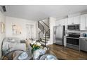 Stylish living room featuring hardwood floors, stainless steel appliances, and modern staircase design at 1305 Osceola St, Denver, CO 80204