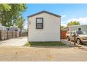 A charming single-story home showcases a simple design with fresh sod and a spacious concrete driveway at 8497 Madison Way, Denver, CO 80229