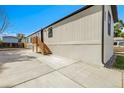 Side view of a charming single-story home with new concrete driveway and newly painted siding at 8497 Madison Way, Denver, CO 80229