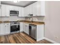 Modern kitchen with stainless steel appliances, sleek white cabinets, and granite counters at 765 S Alton Way # 6B, Denver, CO 80247